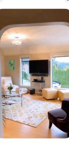 a living room with a couch and a flat screen tv at Sunset Ocean Retreat in West Vancouver