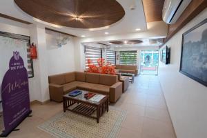a living room with a couch and a table at Hotel The Tulip in Diu