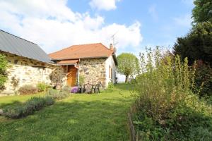 a stone house with a yard in front of it at Les pierres du mas in La Porcherie