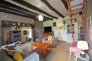 a living room with a couch and a fireplace at Les pierres du mas in La Porcherie