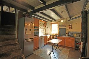 a kitchen with a refrigerator and a table in it at Les pierres du mas in La Porcherie +25 photos