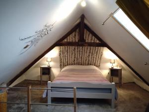 a bedroom with a bed in the attic at Les pierres du mas in La Porcherie