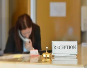 a woman sitting at a desk with a reception sign at Parklane Motel in Launceston +38 photos
