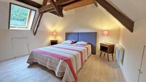 a bedroom with a bed with a striped blanket and a window at Cirèges in Le Chalard