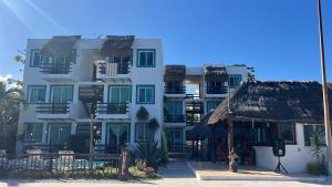 a large white building with a straw roof at Lodge Arenas Costa Maya in Mahahual +7 photos