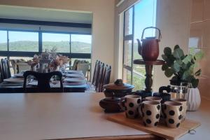 a dining room with a table with cups and a vase at Fynbos & Foam in Herolds Bay
