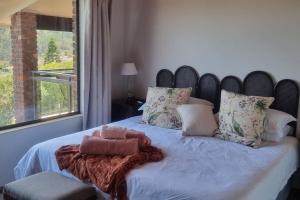a bedroom with a large bed with a large window at Fynbos & Foam in Herolds Bay