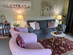 a living room with a blue couch and two chairs at Bush Retreat Farm Stay 1BR Guest Suite in Alberton West +16 photos