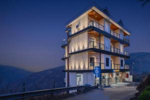 a building on the side of a mountain at night at Hotel Mountain Mirage in KumhÄrsain