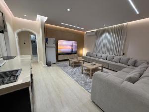 a living room with a couch and a flat screen tv at رولارا بلازا in Medina