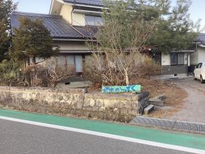 a house with a wall with graffiti on it at 森のしずく in Azumino
