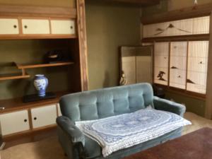a blue couch in a living room with a mirror at 森のしずく in Azumino