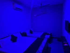 a blue room with a bed and a tv at Teja Residency in Alāndurai