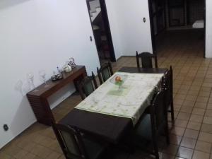 a dining room with a table and a table and chairs at Pousada Cama & Café in Navegantes