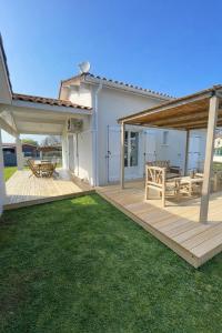 a backyard with a wooden deck and a picnic table at Maison côté lac in Parentis-en-Born