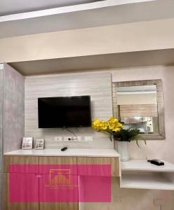 a living room with a tv on a wall at Janeeka's Airie Avida Riala Cebu in Cebu City