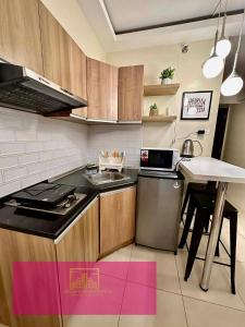 a kitchen with a stove and a sink and a table at Janeeka's Airie Avida Riala Cebu in Cebu City