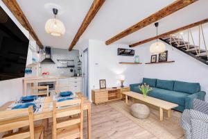 a living room with a blue couch and a table at Káli Kert Vendégház in Szentbékkálla