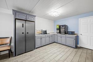a kitchen with a refrigerator and a table and chairs at Super 8 by Wyndham Kingsport /I-81 in Kingsport
