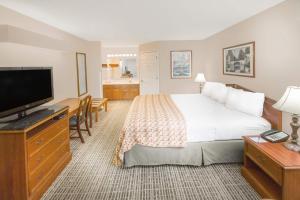 a hotel room with a bed and a flat screen tv at Baymont by Wyndham Grenada in Grenada
