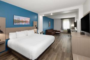 a hotel room with a white bed and a blue wall at La Quinta by Wyndham Kyle - Austin South in Kyle
