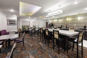 a restaurant with tables and chairs and a bar at La Quinta by Wyndham Kyle - Austin South in Kyle