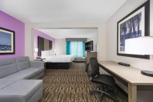 a hotel room with a couch and a bed at La Quinta by Wyndham Clarksville in Clarksville