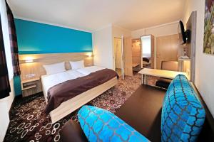 Habitación de hotel con 1 cama y 2 sillas en Hotel sleep & go, en Bad Hersfeld