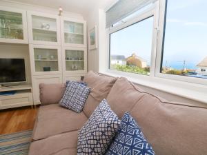 a living room with a couch and a large window at Atlantic Waves in Carbis Bay