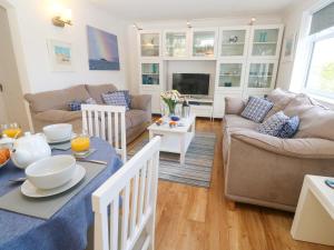 a living room with a couch and a table at Atlantic Waves in Carbis Bay
