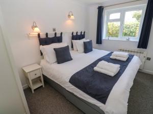 a bedroom with a large bed with blue and white pillows at Atlantic Waves in Carbis Bay