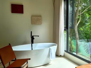 a bath tub in a bathroom with a window at Taofanting Riverside Hotel in Yichang +48 photos