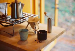 a counter with three cups and a tea kettle on it at awake Gojome in Akita