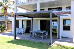 awning over a patio with a table in front of a house at Horizons Unit 2 Beachfront Unit in Bargara