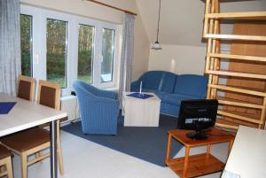 ヴィッテにあるDoppelhaushälfte in Vitte auf Hiddenseeのリビングルーム(青いソファ、テーブル付)