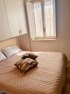 a bed with a pillow on it in a bedroom at Alloggio nel Borgo Marinaro in Cittadella del Capo