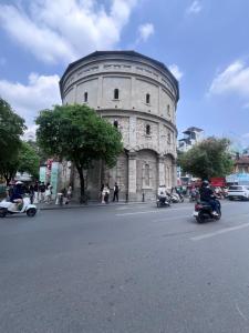 a building with people riding motorcycles in front of it at Moon Inn Apartment-self check in in Hanoi