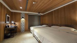 ein Hotelzimmer mit zwei Betten und einem Tisch in der Unterkunft GOGO Hotel City Hall in Taichung