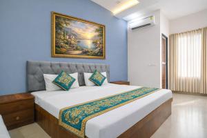 a bedroom with a large bed with a painting on the wall at Hotel Tirupati Heights Ujjain # Near Railway Station # Top Rated Property in Ujjain