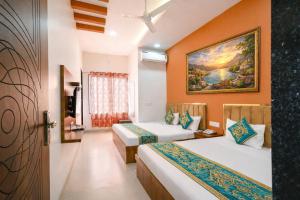 a bedroom with two beds and a painting on the wall at Hotel Tirupati Heights Ujjain # Near Railway Station # Top Rated Property in Ujjain