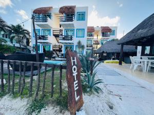 a sign in the sand in front of a hotel at Lodge Arenas Costa Maya in Mahahual