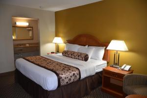 una habitación de hotel con una cama grande y una silla en Regency Inn, en Chickasha