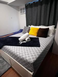 a bed in a room with two pillows on it at Family Haven Tagaytay - 1 BR - up to 6 Pax - Taal View - Full Kitchen - FAST Wi-Fi - in Tagaytay +31 photos