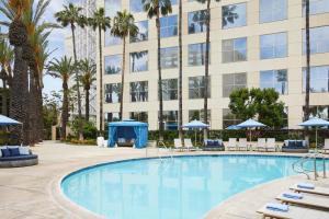 a swimming pool with chairs and a building at Hyatt Regency Orange County in Anaheim