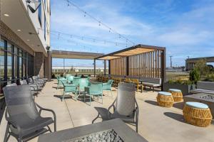 a patio with chairs and tables on a building at Home2 Suites By Hilton Calera in Calera