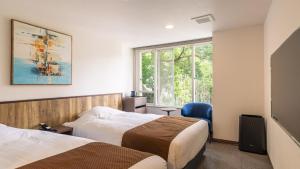 ein Hotelzimmer mit zwei Betten und einem Fenster in der Unterkunft HOTEL nehako in Hakone + 64 Fotos