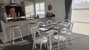 a kitchen with a table and four stools at Huntington Hideaway in Hamilton
