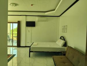 a living room with a bed and a couch at Safe Haven Residence in Talibon