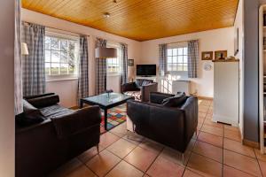a living room with couches and a table at Ferienhuus Wietkieker in Nordstrand