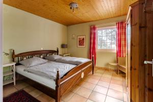 a bedroom with a wooden bed and a window at Ferienhuus Wietkieker in Nordstrand